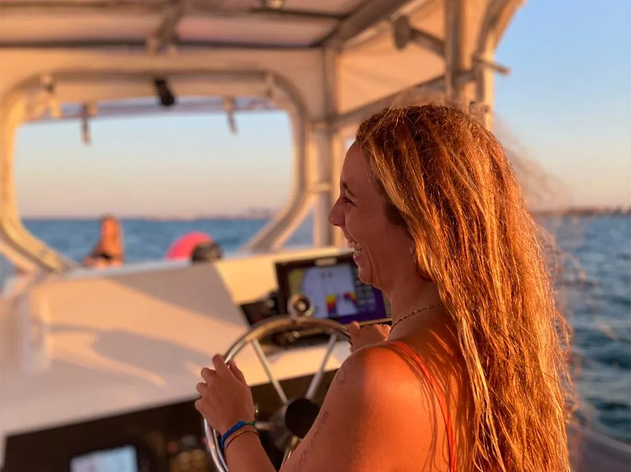 Patrona al timón de la lancha durante la navegación